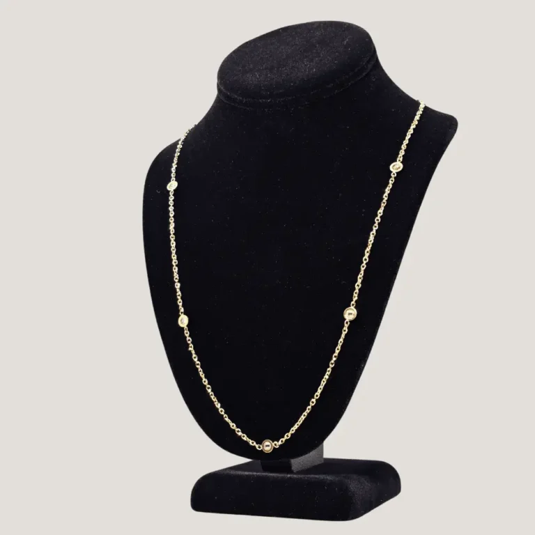 Gold necklace with gemstones on display