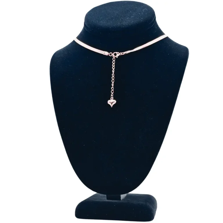 Silver necklace with heart pendant on display